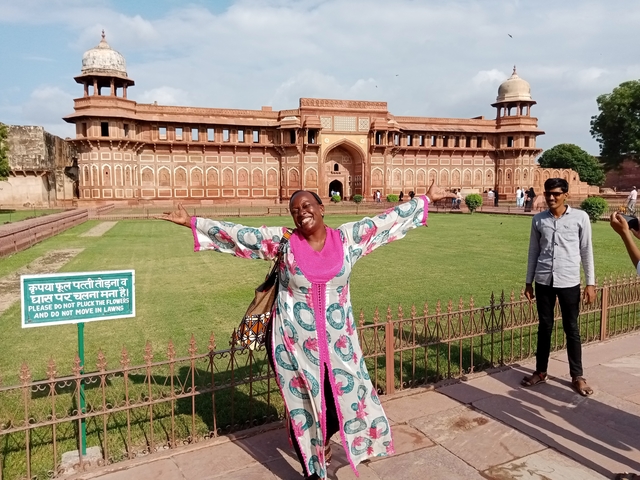 Woman posing cheerfully in front of a historic fort.