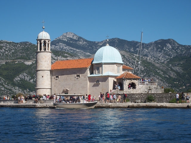       Historic island church with a dome and boat in the foreground.
  