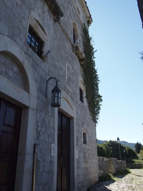       Close-up of a stone building facade with a lantern.
  