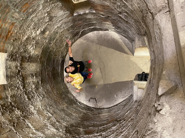 Two people looking up in a cylindrical structure.