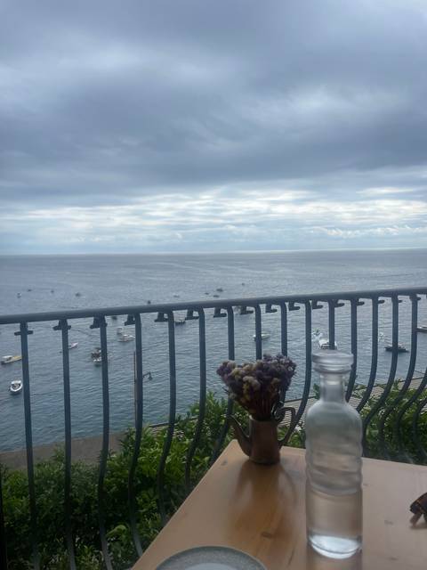 Table with bottle and flowers overlooking the sea