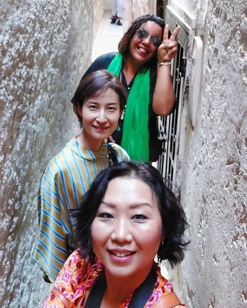       A group of people walking through a narrow alleyway.
  