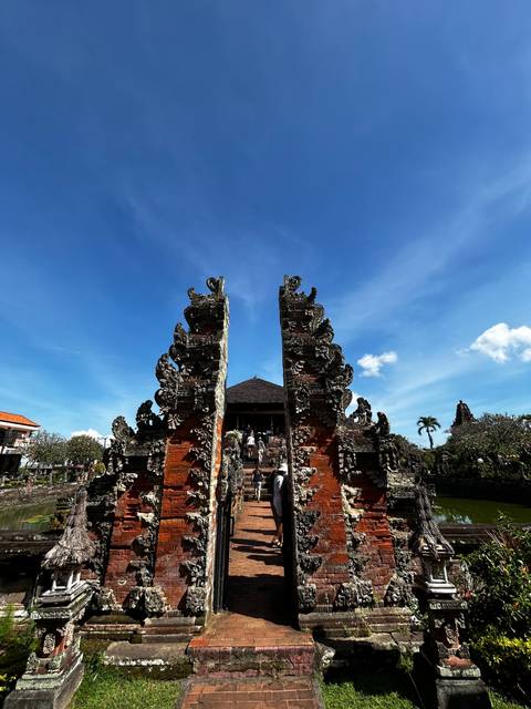 Intricately carved temple gate against a blue sky.