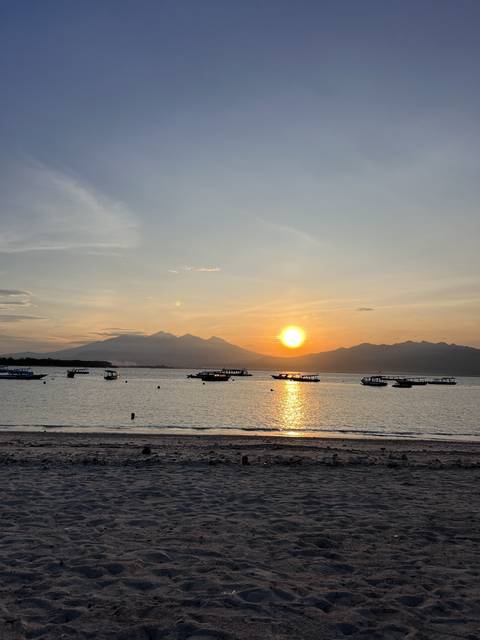 Sunset over the ocean with boats