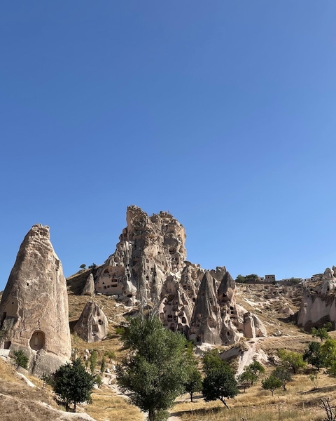 Rocky formations of Uchisar Castle under a blue sky.