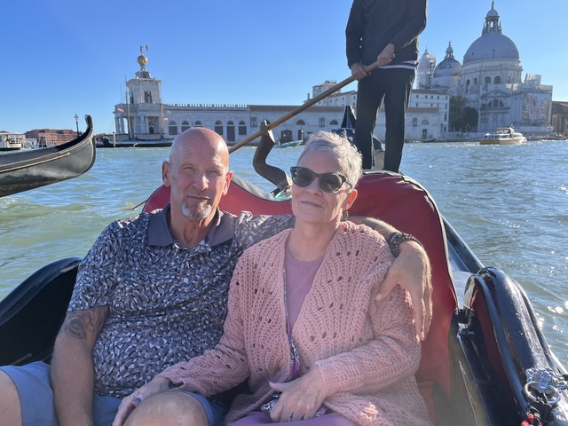 Couple enjoying a gondola ride with scenic backdrop.
