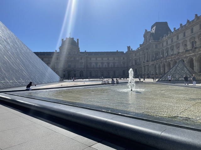 The Louvre Pyramid with fountains in the foreground.
