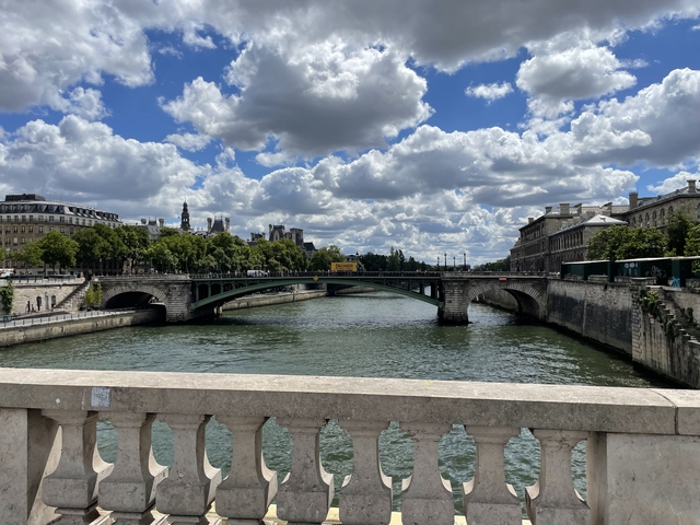 Arch bridge over a river with cloudy sky.