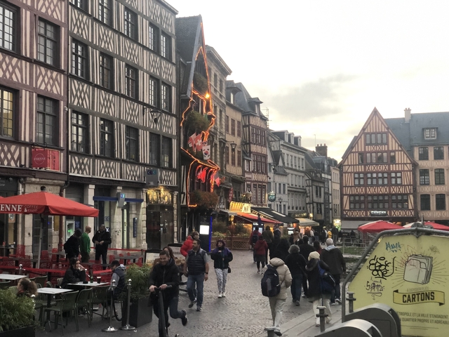 Street scene in Rouen with people and historic buildings.