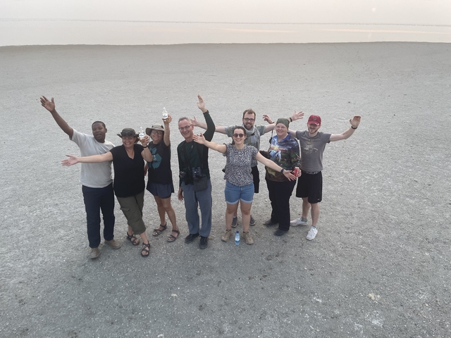       Group photo of people in a desert landscape.
  