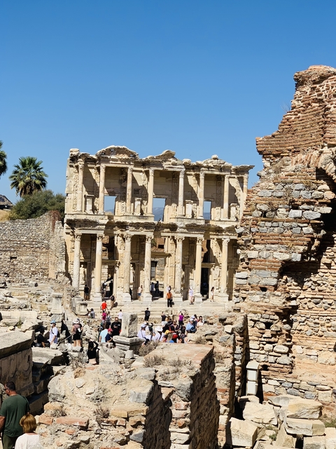 Ancient stone ruins of a Roman library with people visible.