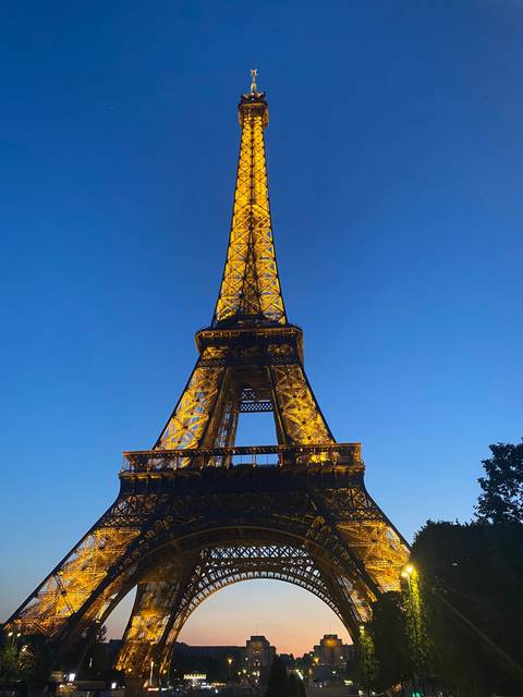 Eiffel Tower lit up at night with a clear sky.