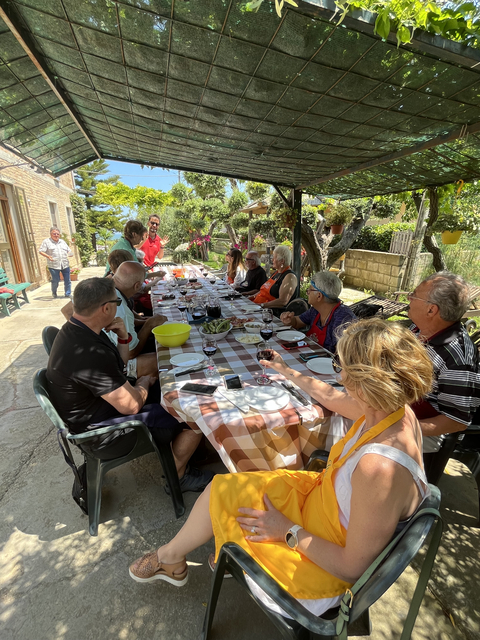 Large group enjoying a meal at an outdoor table.