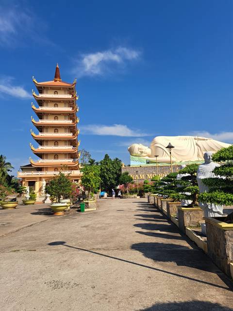 Large statue of reclining Buddha with concrete stairway.