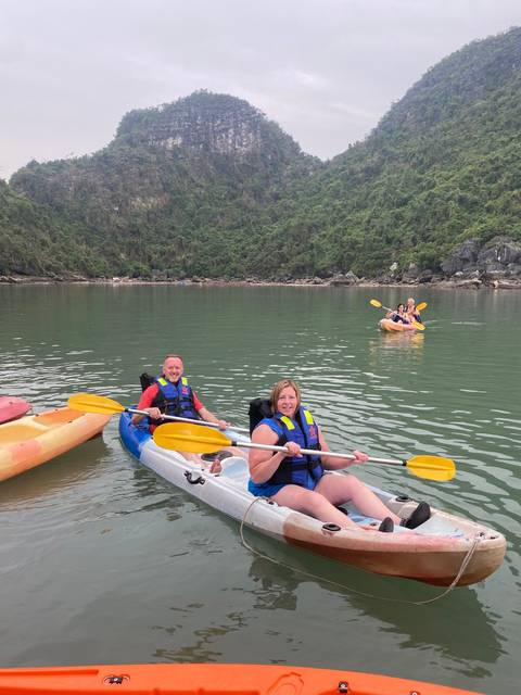 Group of people kayaking in a scenic bay.