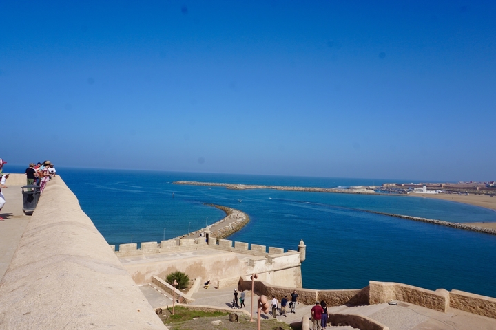 People on a coastal fort with blue sea