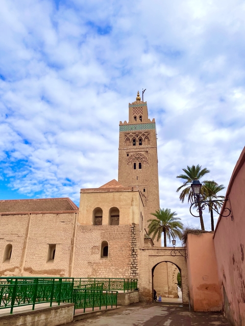       Tall mosque tower with palm trees
  