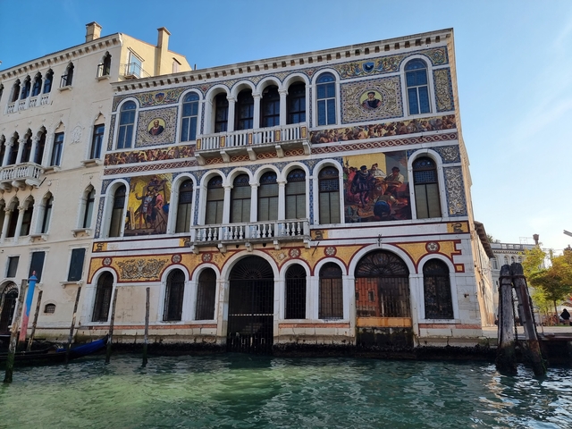 Ornate building with colorful mosaics by the water.