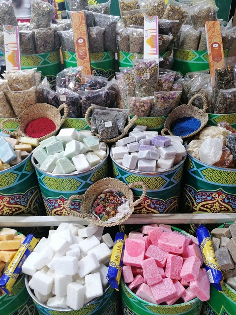       Bins of colorful soaps and spices in a market.
  