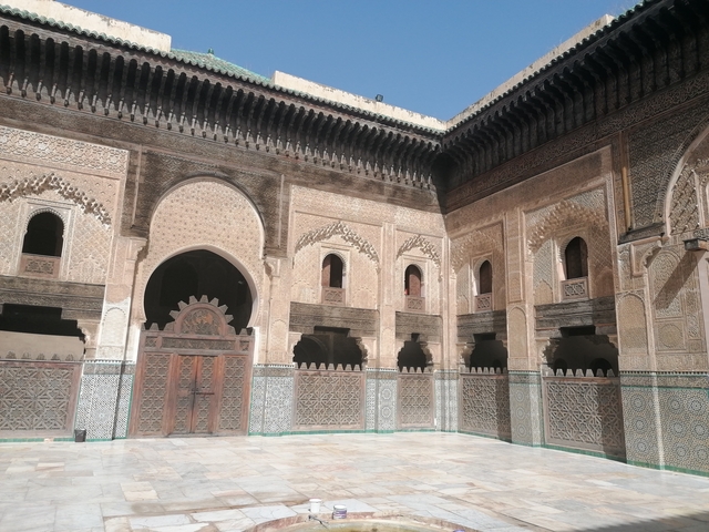       Historic courtyard with intricate design and arches.
  