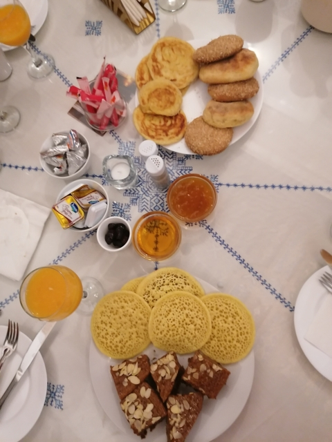       Table with assorted breakfast items including pancakes and drinks.
  
