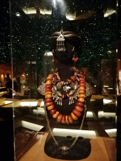       Display of traditional jewelry under glass with a starry background.
  
