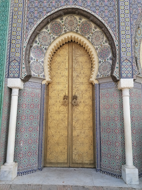       Ornate golden door with intricate patterns and mosaics.
  