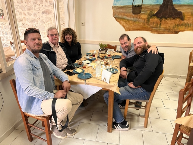       Group of people dining at a restaurant table.
  