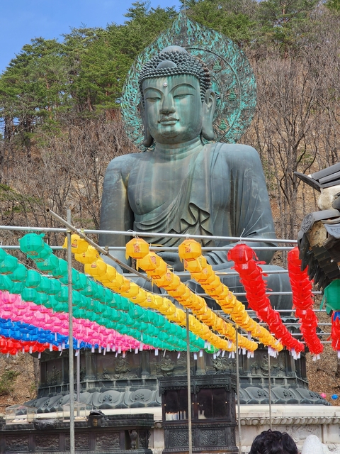 Buddha statue with colorful lanterns in the foreground.