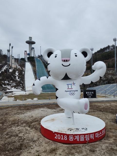       PyeongChang 2018 Winter Olympics mascot sculpture in front of ski slopes.
  