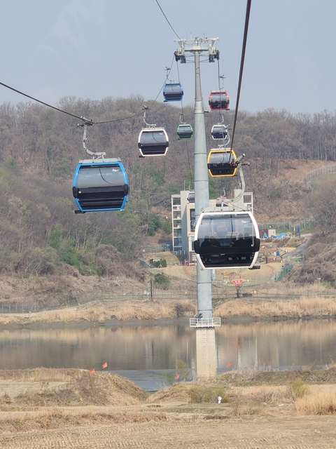       Cable cars overlooking a rural landscape.
  