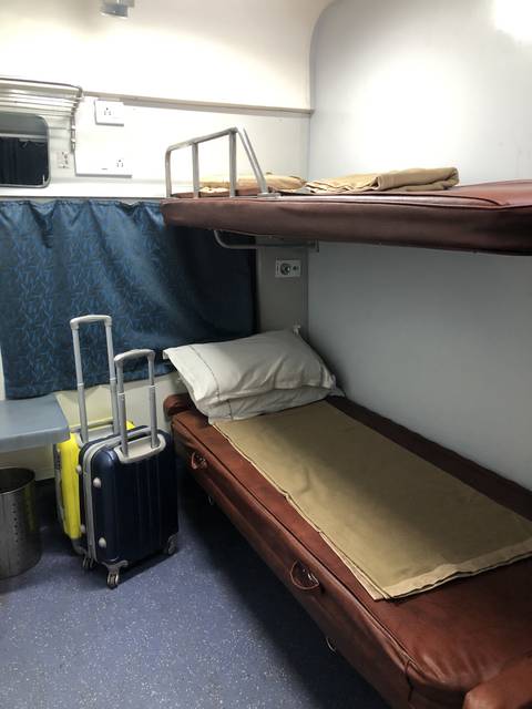       Interior view of a train compartment with luggage.
  