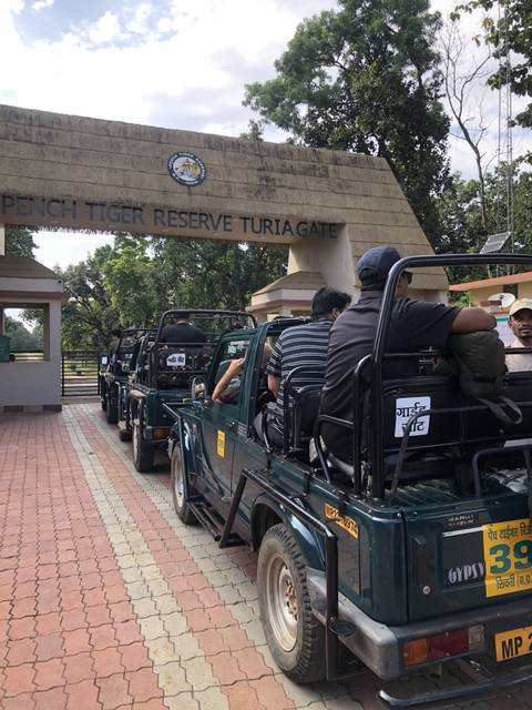       Jeep safari with passengers entering a national park gate.
  