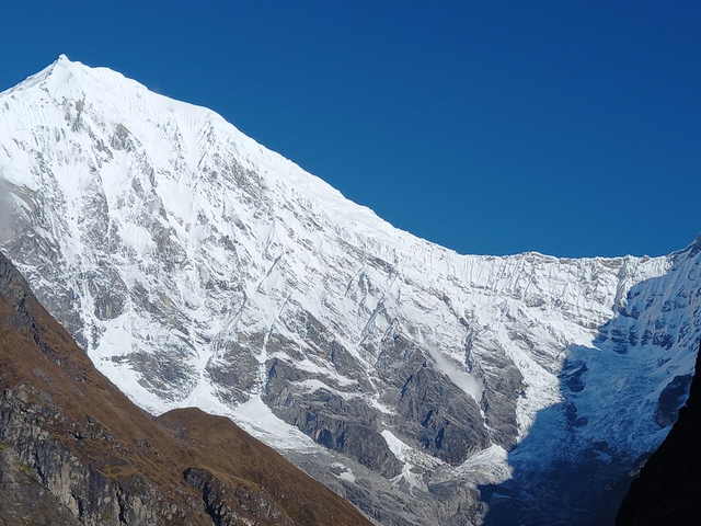 A pristine snowy mountain under a blue sky.
