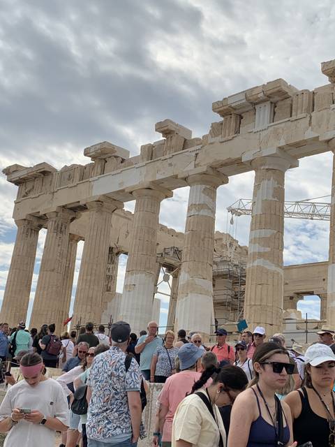 Ancient ruins with tourists gathered around.