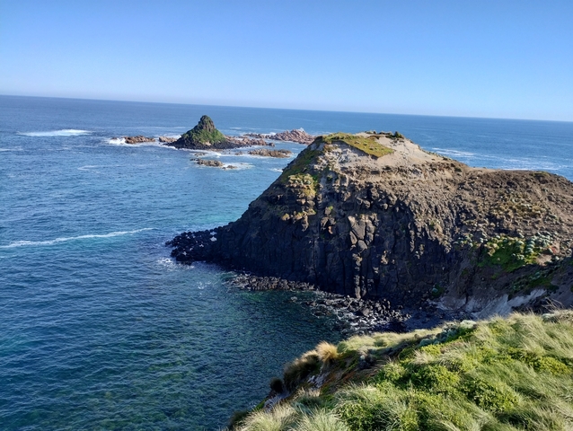 Rocky coastline with ocean and a small island.