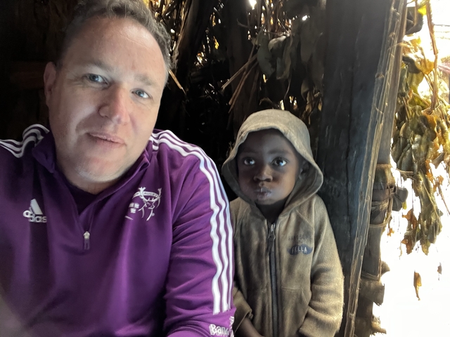       Two people sitting inside a dimly lit wooden structure.
  