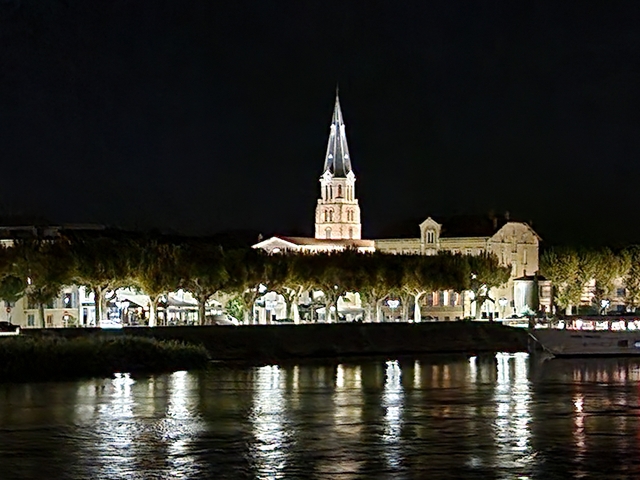 Architectural building by a river illuminated at night.