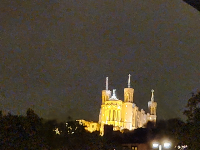 Blurry night view of a large, illuminated cathedral.