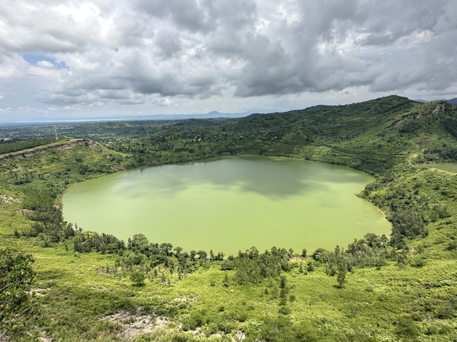 A large circular lake surrounded by green hills.