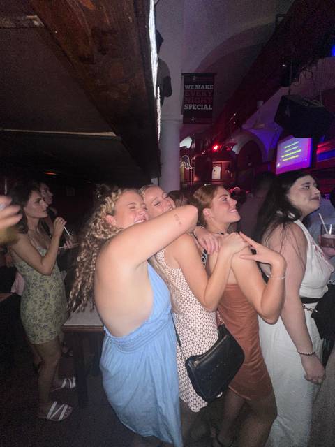 People smiling in a dimly lit bar or club.