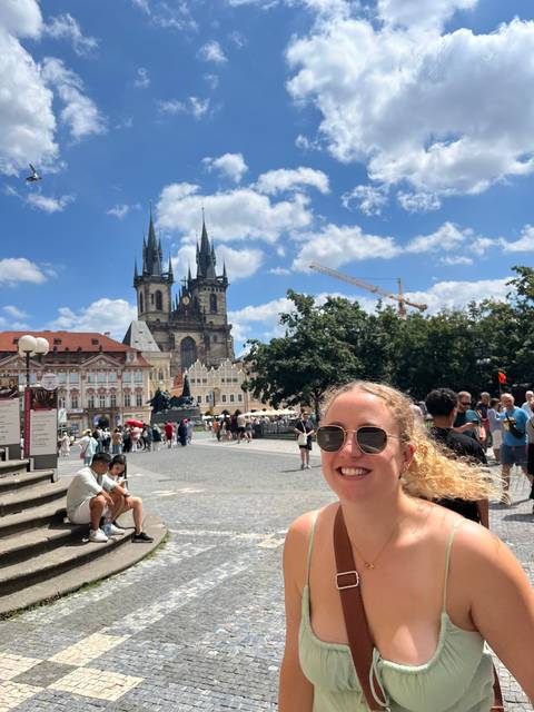 Woman smiling with a historic church in the background.