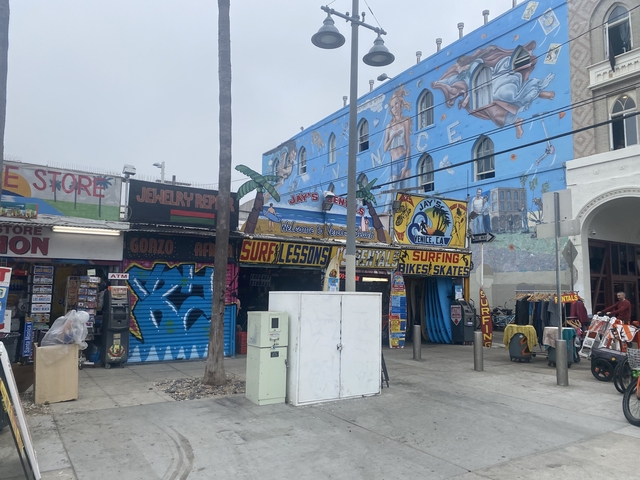 Colorful storefronts and murals in a vibrant neighborhood.