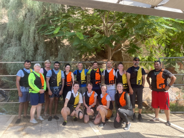 Group of people in colorful life vests posing together.