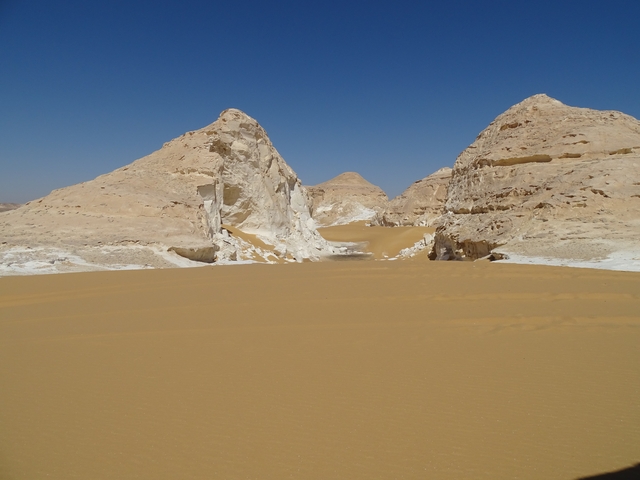       Barren desert landscape with unique white rock formations.
  
