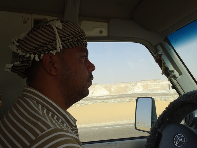       Close-up of a driver in a desert setting.
  
