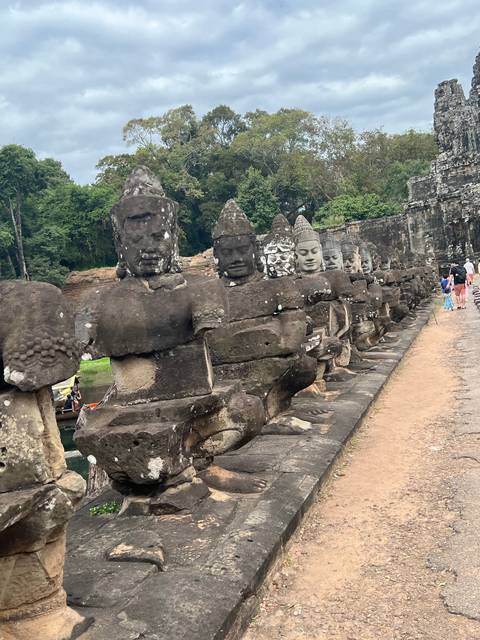       Row of ancient statues along a pathway.
  