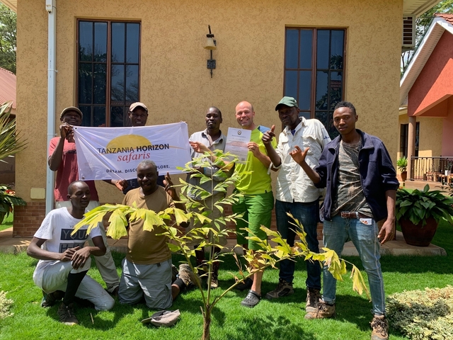       Group of people holding a safari banner in front of a building.
  