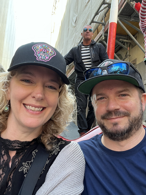 Close-up of two people smiling with a gondolier in the background.