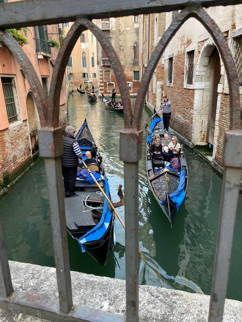 Gondolas on a Venetian canal with historic buildings nearby.